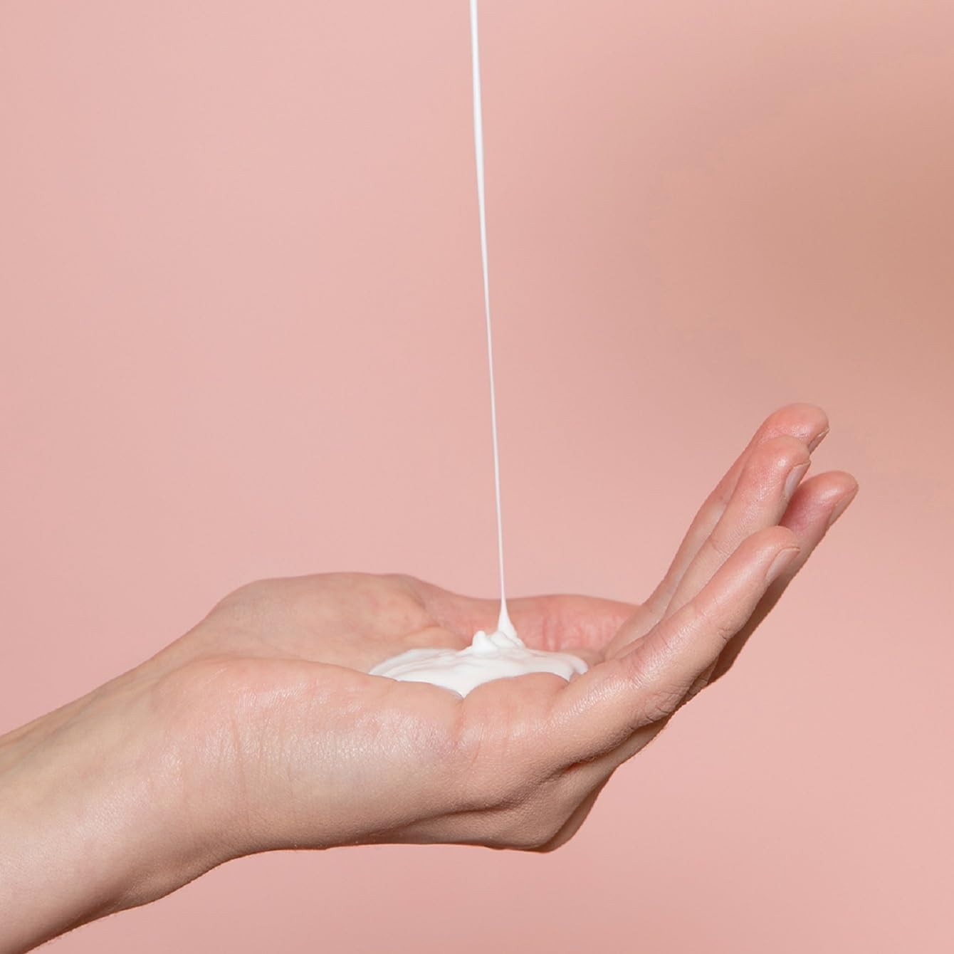 White lotion drop on hand from Topicrem Ultra Hydratant body milk