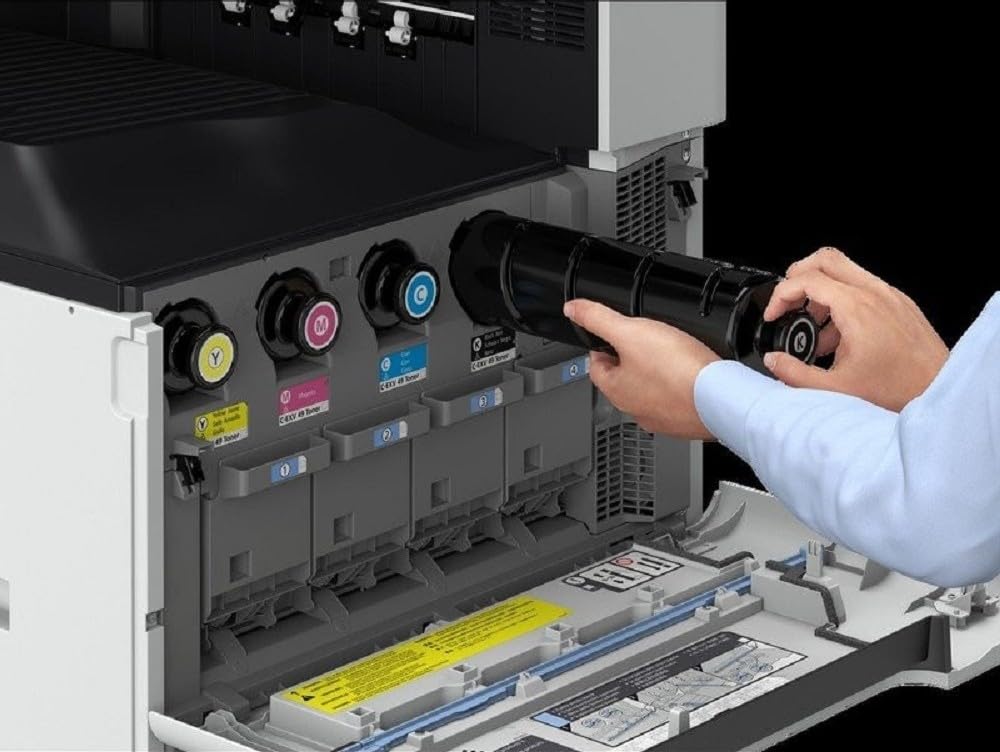Printer interior showing toner slots with cartridges being installed by hand