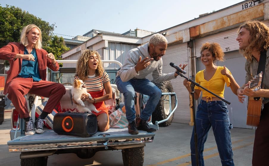 Handheld JBL microphone held by performers during outdoor singing and music
