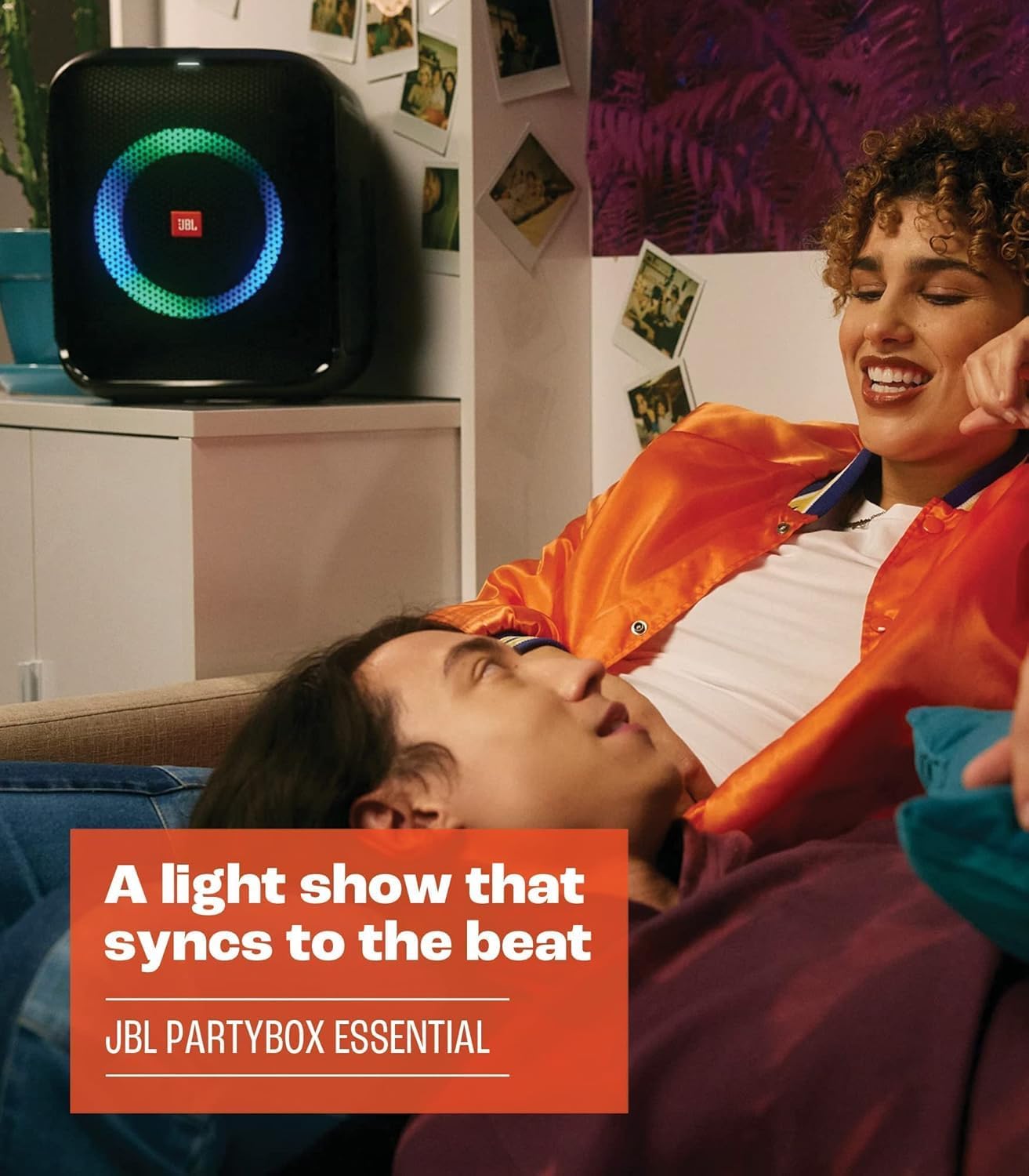JBL PartyBox portable Bluetooth speaker with glowing circle light near a couch