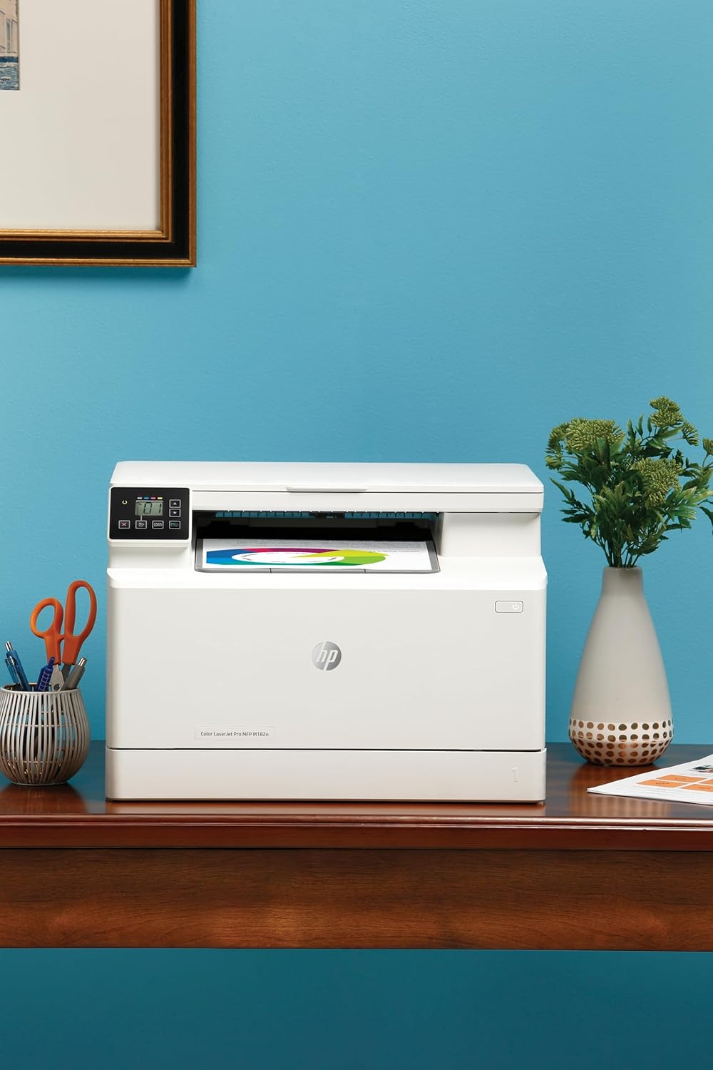 HP Color LaserJet Pro MFP M182n color laser printer on desk with lit control panel