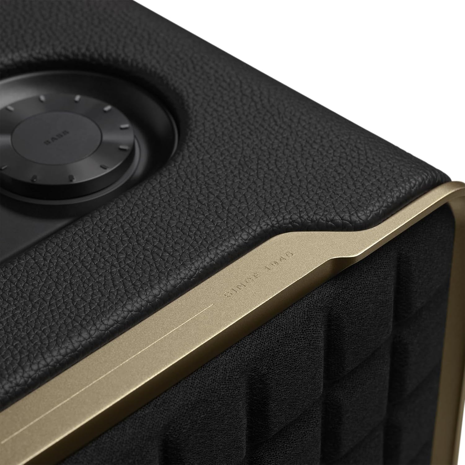 Close-up of black speaker top with circular controls and gold edge trim