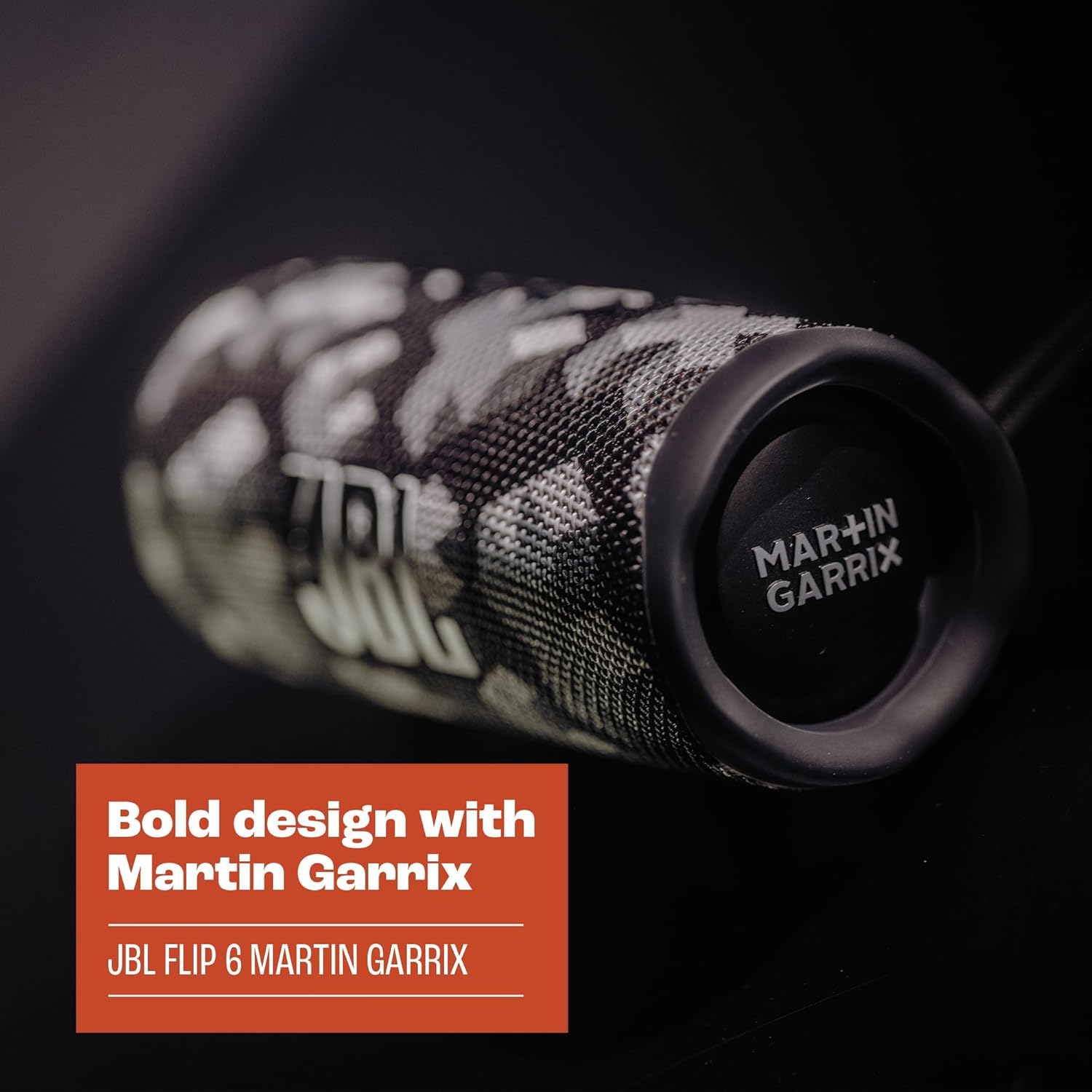Close-up of JBL Flip 6 speaker end with Martin Garrix branding and camo fabric