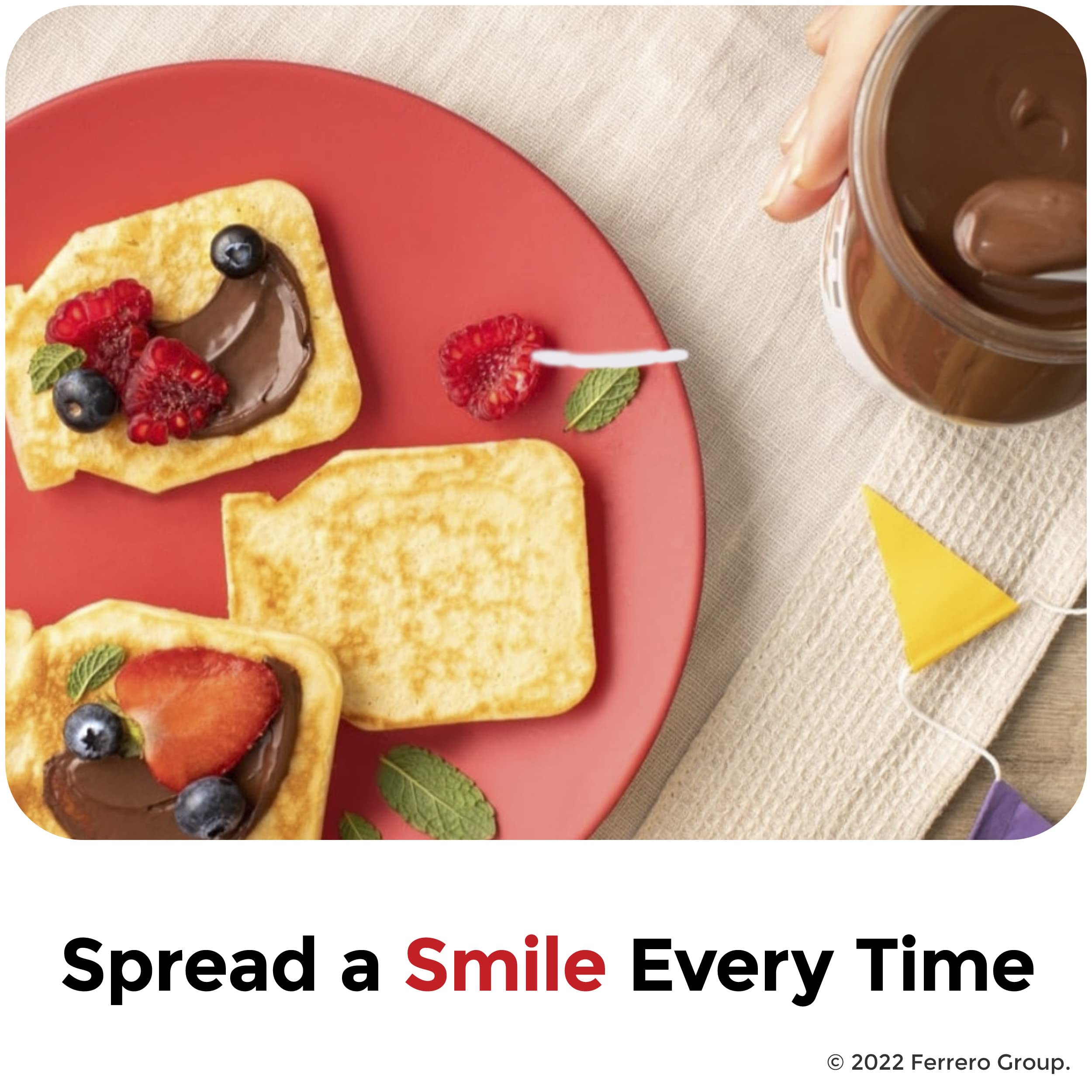 Chocolate-hazelnut spread jar beside toast topped with fruit and berries on plate