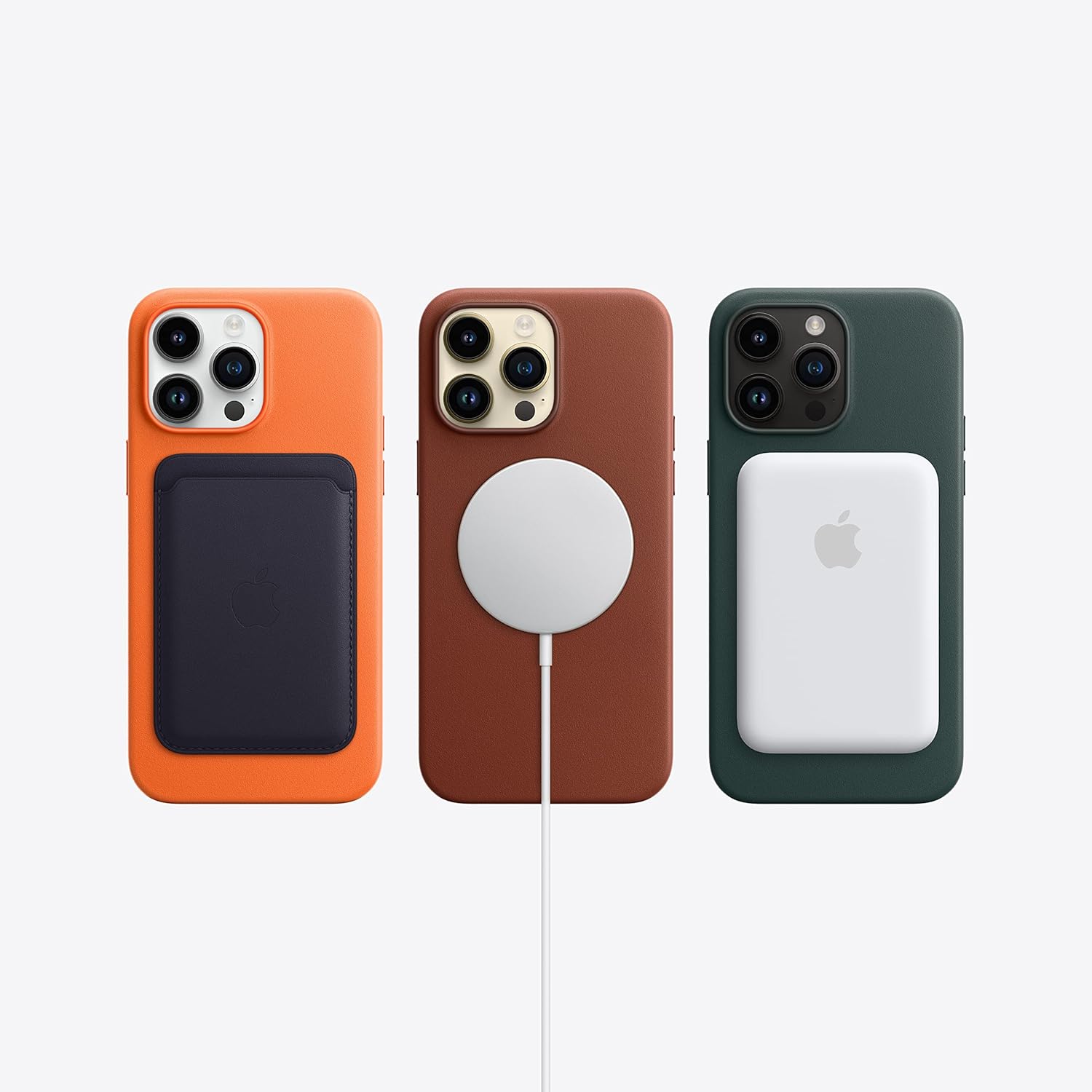 Three iPhone 14 Pro Max phones in orange, brown, and dark green with MagSafe-style pad