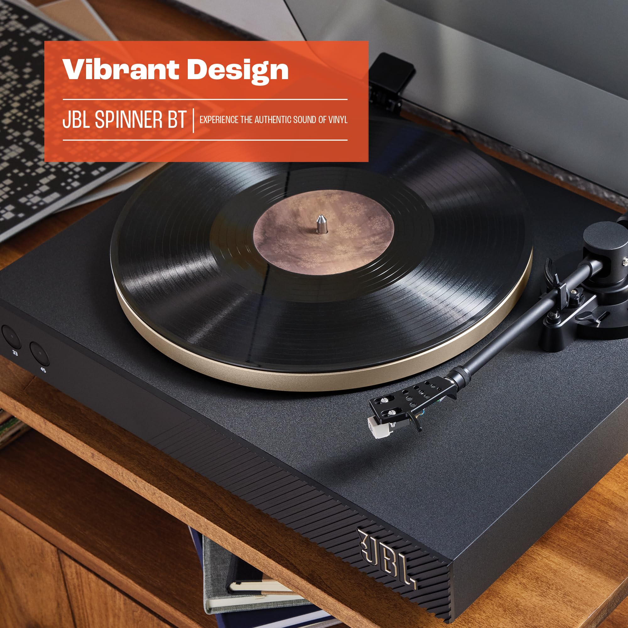 Close-up black JBL turntable with vinyl record, gold-ring platter, and tonearm