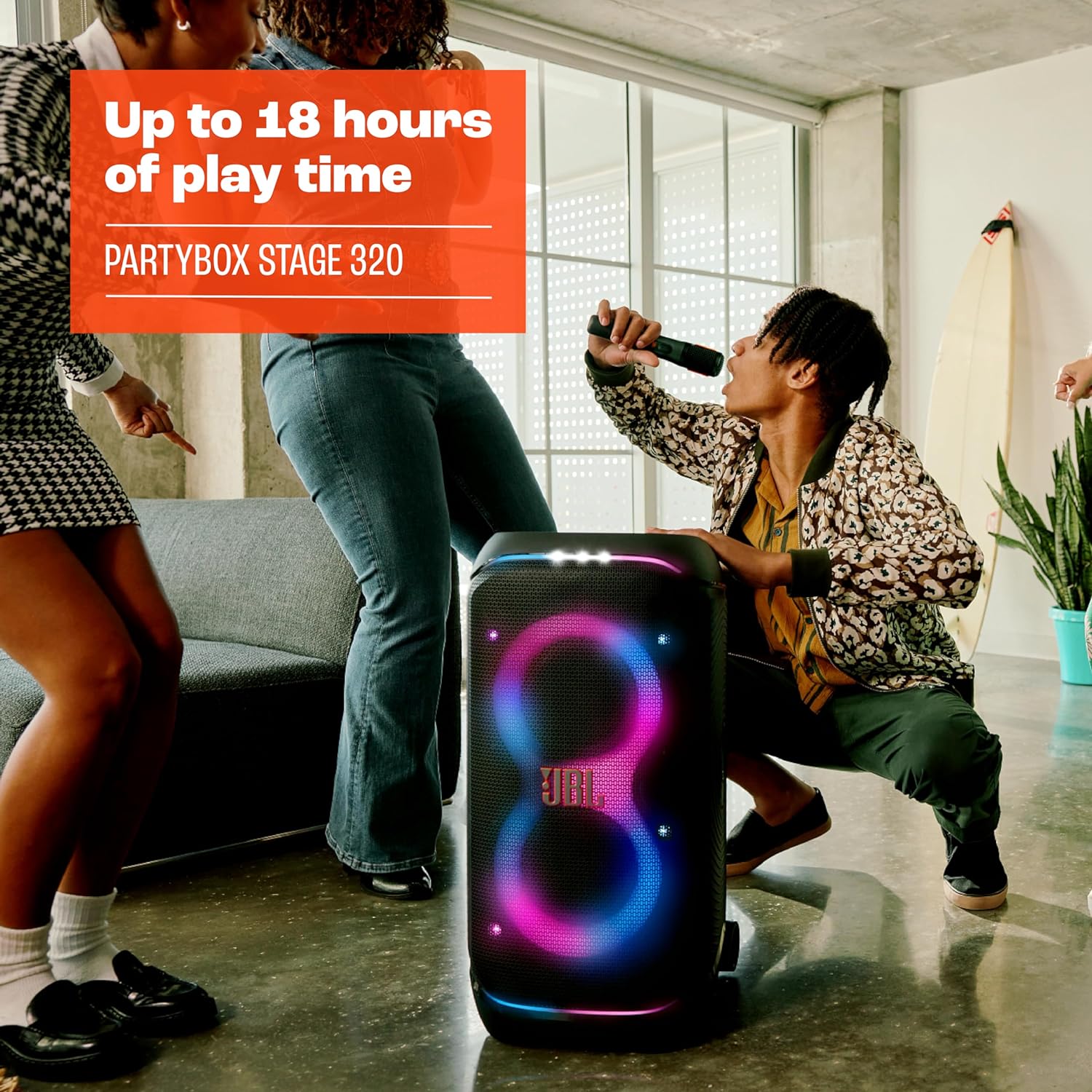 Portable JBL PartyBox speaker with glowing LED lights on a living room floor