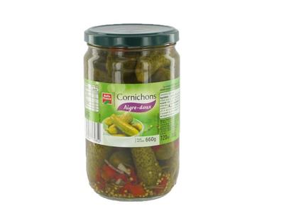 Glass jar of pickled cornichons (sweet-sour), green lid, French-style label