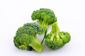 Broccoli florets with green heads and fresh stems, three pieces arranged