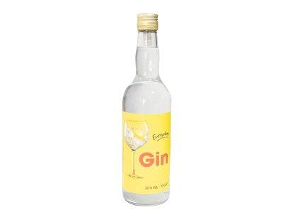 Gin bottle with cork top, clear glass, gold 'Gin' label and amber liquid