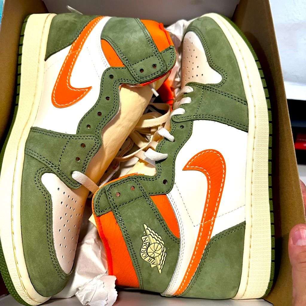 Air Jordan 1 sneakers in green with white panels and orange swoosh, side view pair