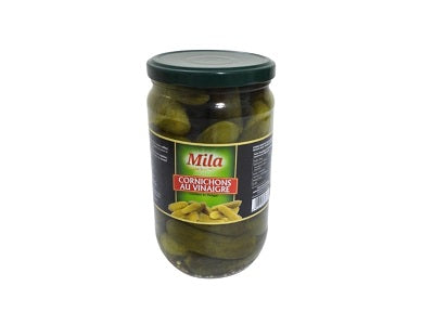 Jar of Mila cornichons in vinegar, glass jar with green pickles and dark label
