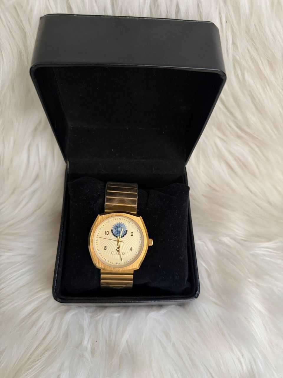 Gold-tone square analog watch with white dial and roman numeral markers