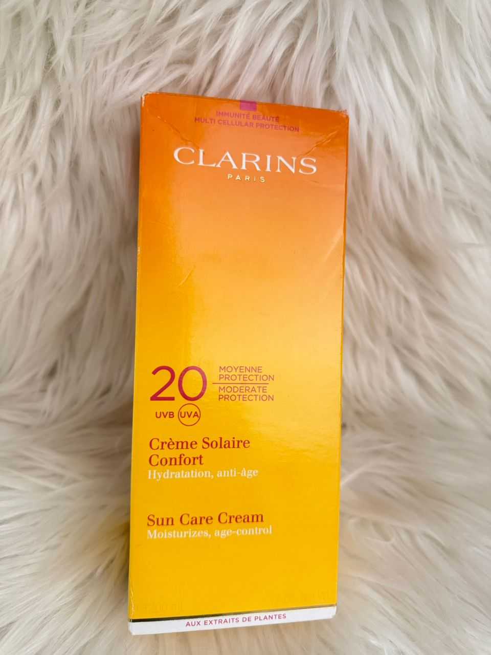 Clarins SPF 20 sun care cream box, orange packaging with “20 protection” text