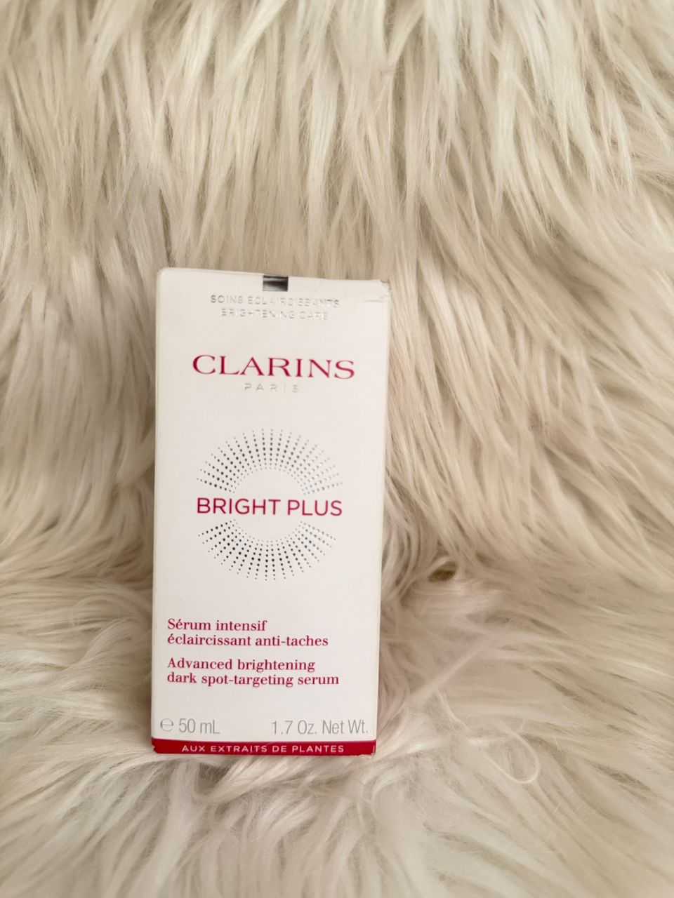 Clarins Bright Plus serum box, white with pink text and dotted glow graphic
