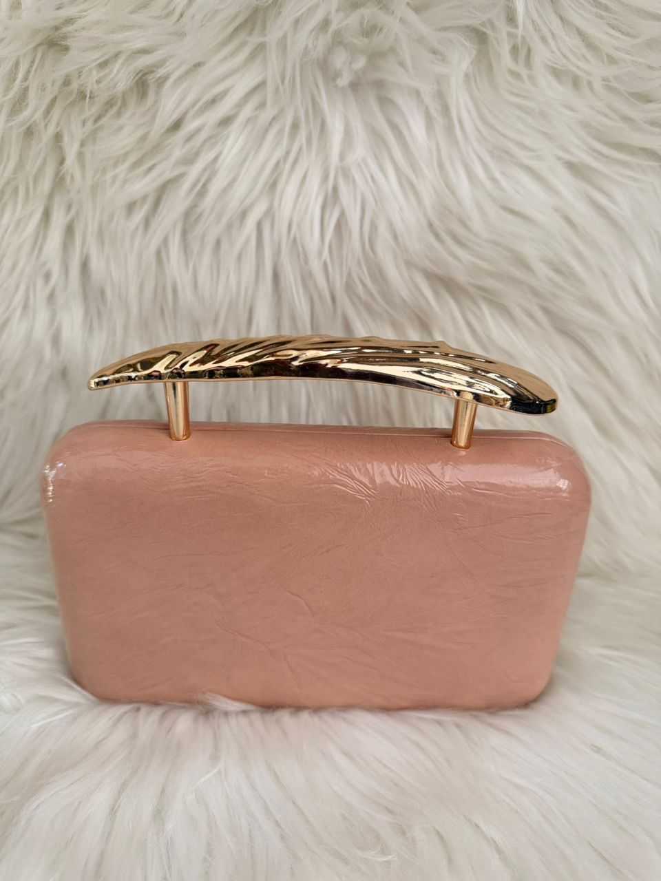 Light pink clutch handbag with gold-tone top frame and short handle