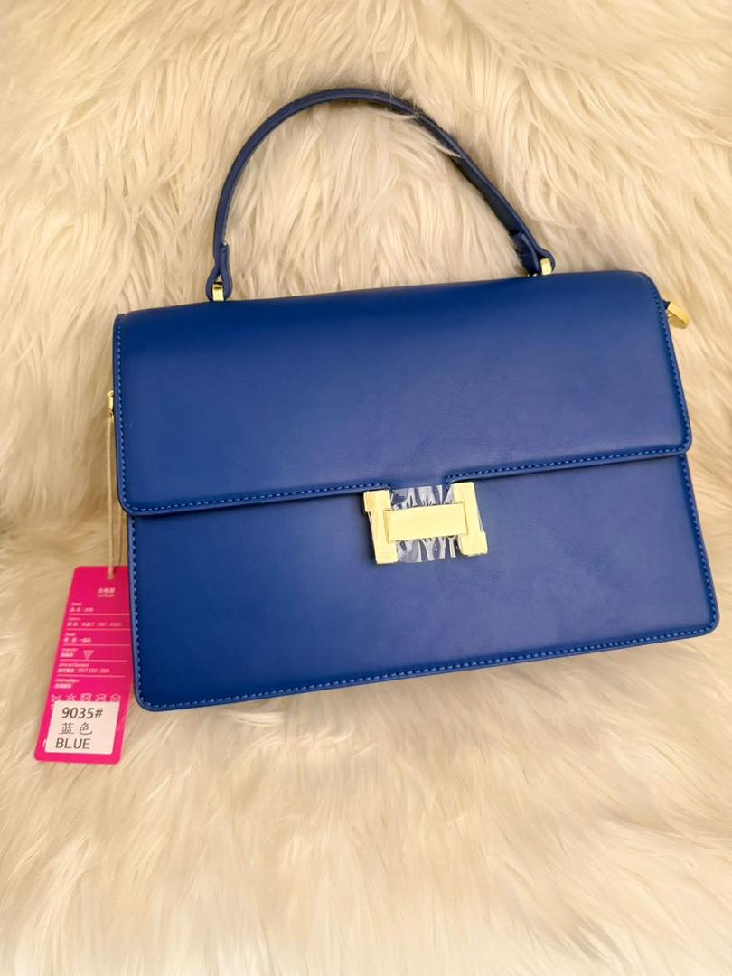 Royal blue structured flap handbag with top handle and gold front clasp