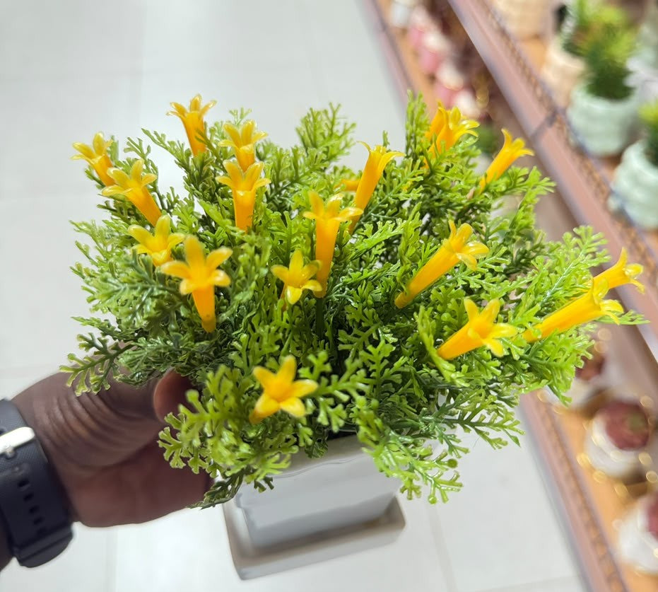 Artificial mini lily plant with yellow flower clusters and bright green leaves in white pot