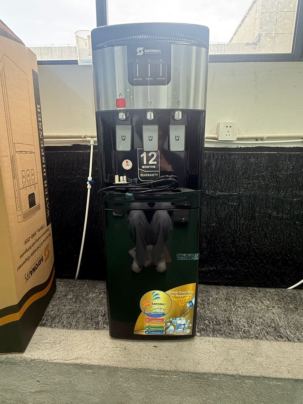 Dark water dispenser with front control panel, drip tray, and bottle holder