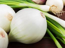 White onions with green stems, fresh whole bulbs