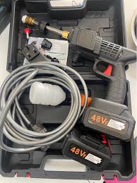 Cordless high-pressure washer kit in a case with hose, spray gun, and two batteries